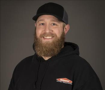 male servpro employee with beard and baseball hat in front of blank background