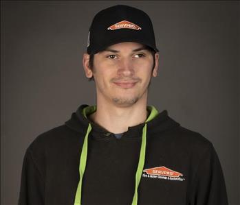 male servpro employee wearing baseball cap in front of blank background