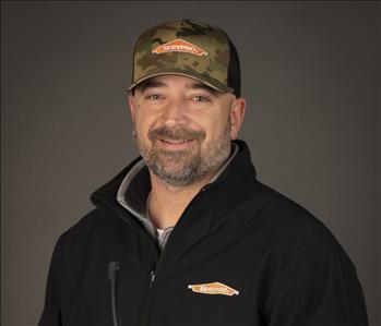 male servpro employee wearing baseball cap in front of blank background