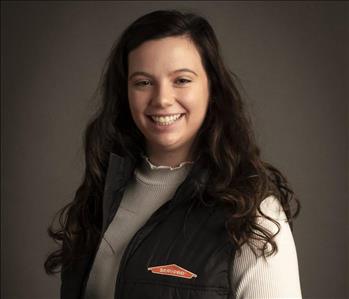 female servpro employee wearing vest in front of blank background