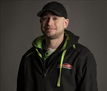 male servpro employee wearing baseball cap in front of blank background